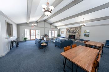 A spacious room with a fireplace and a dining table set up